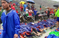 People gather near the bodies of victims of a landslide near a jade mining area in Hpakant, Kachine state, northern Myanmar Thursday, July 2, 2020. Myanmar government says a landslide at a jade mine has killed dozens of people. (AP Photo/Zaw Moe Htet)