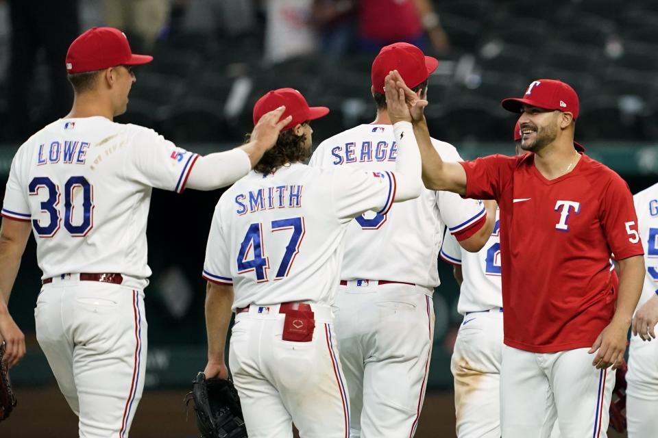 Texas Rangers' Nathaniel Lowe (30). Josh Smith (47), Corey Seager and starting pitcher Martin Perez, right, celebrate the team's 9-7 win in a baseball game against the Minnesota Twins, Saturday, July 9, 2022, in Arlington, Texas. (AP Photo/Tony Gutierrez)