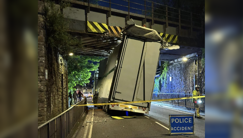 A crashed HGV lorry stuck underneath a railway bridge in Newport