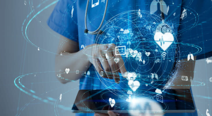 Nurse holding a tablet with icons representing different aspects of healthcare and healthcare data.