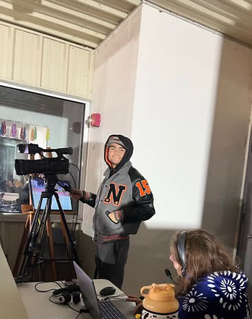 A camera man using JVC cameras at a high school football game.