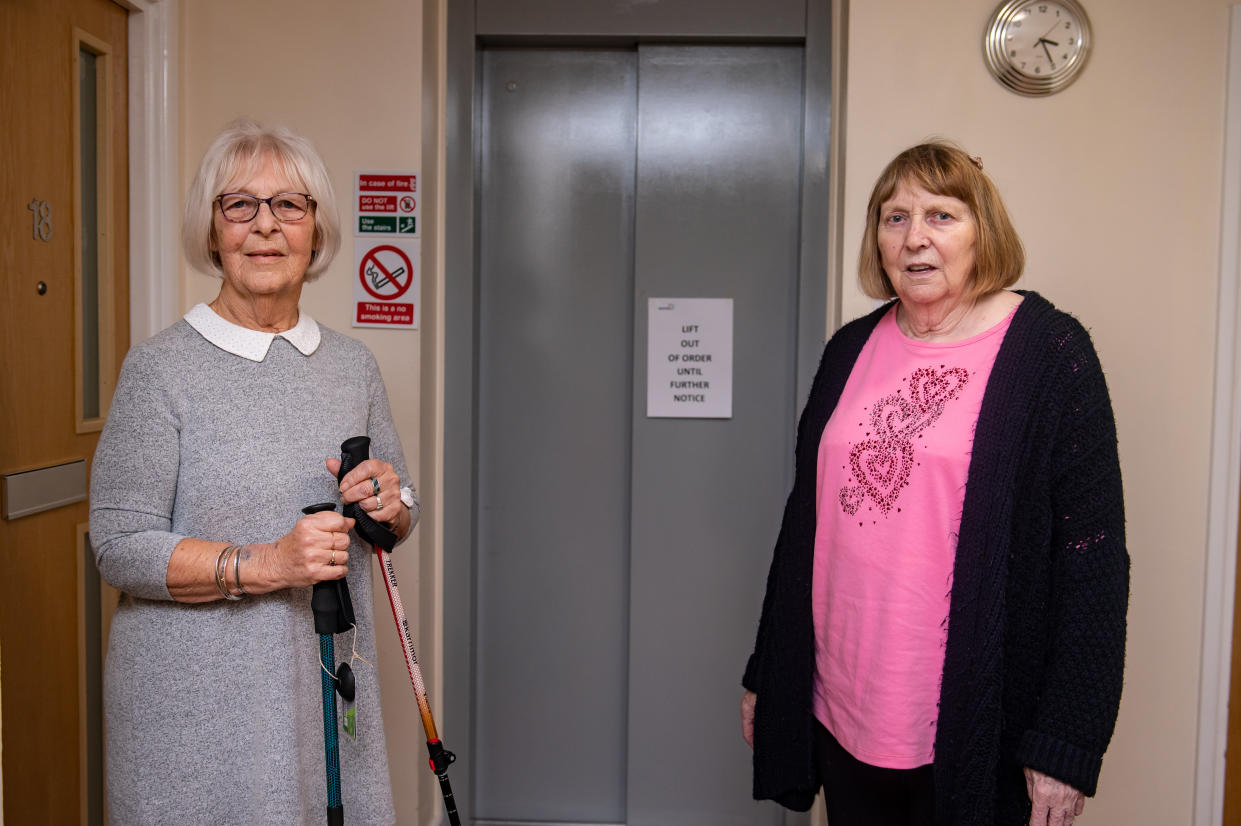 Carol Jones-Evans and Ann Baker next to the broken lift in Hanover House. (SWNS)