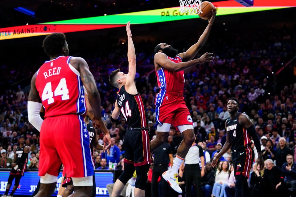 Philadelphia 76ers' James Harden, right, goes up for a shot against Miami Heat's Tyler Herro (14) during the second half of Game 4 of an NBA basketball second-round playoff series, Sunday, May 8, 2022, in Philadelphia. (AP Photo/Matt Slocum)