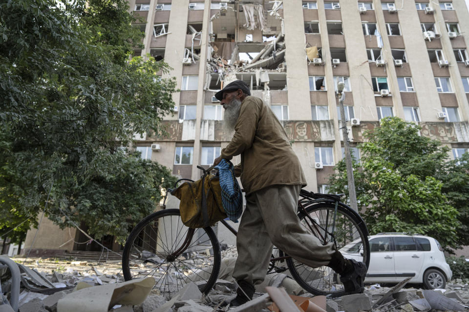 A man walks in front of a building which was heavily damaged by a Russian airstrike in Kherson, Ukraine, Thursday, June 15, 2023. (AP Photo/Evgeniy Maloletka)