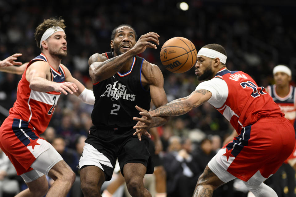 Washington Wizards center Daniel Gafford (21) fouls Los Angeles Clippers forward Kawhi Leonard (2) during the first half of an NBA basketball game, Wednesday, Jan. 31, 2024, in Washington. Wizards forward Corey Kispert is at left. (AP Photo/Nick Wass)