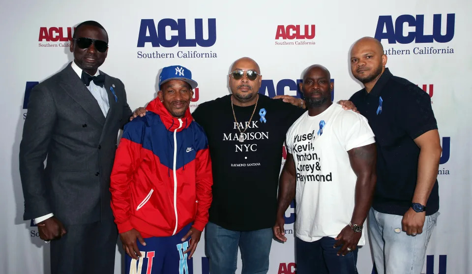 Yusef Salaam, Korey Wise, Raymond Santana, Antron McCray and Kevin Richardson pose in front of a wall posted with the designation: ACLU Southern California.