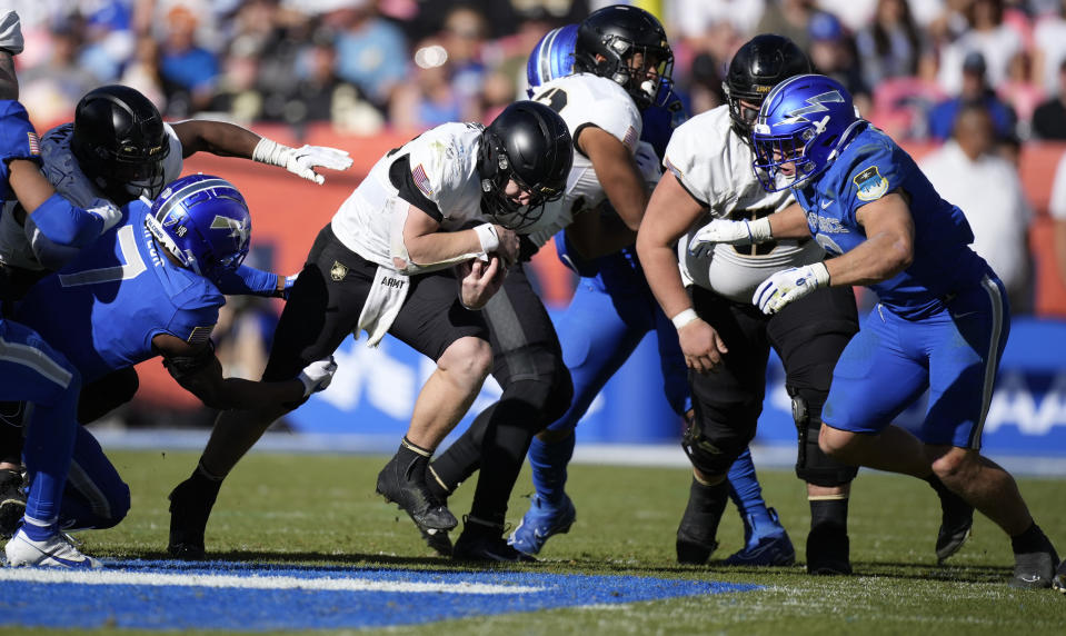 Army quarterback Bryson Daily, center, drives for a short gain between Air Force safety Trey Taylor, left, and defensive back Jakobi McGowan in the second half of an NCAA college football game Saturday, Nov. 4, 2023, in Denver. (AP Photo/David Zalubowski)