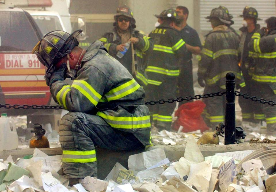 Firefighter Gerard McGibbon, of Engine 283 in Brownsville, Brooklyn, prays after the buildings collapsed (Getty)