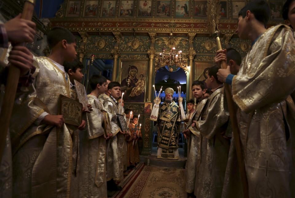 Palestinian Orthodox Christians celebrate Palm Sunday at Gaza's Church of Saint Porphyrius, named after the 5th century bishop of Gaza, in Gaza City, Sunday, April 13, 2014. Palm Sunday marks for Christians, Jesus Christ's entrance into Jerusalem, when his followers laid palm branches in his path. There are approximately 2500 Christians among an overall Palestinian population of more than 1.7 million in Gaza. (AP Photo/Hatem Moussa)