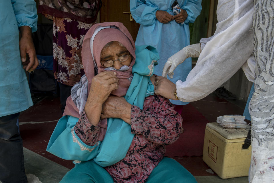 A health worker administers the AstraZeneca vaccine for COVID-19 to a Kashmiri woman after persuading her to take the shot in Tral village south of Srinagar, Indian controlled Kashmir, Saturday, June 5, 2021. (AP Photo/ Dar Yasin)