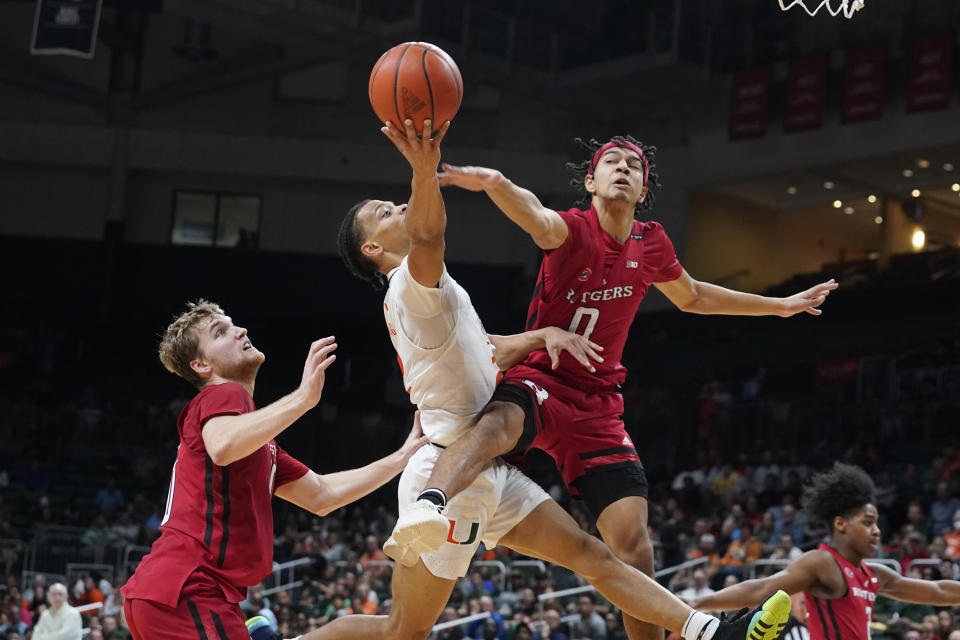 Miami's guard Isaiah Wong (2) drives to the basket as Rutgers' guard Derek Simpson (0) defends during the first half of an NCAA college basketball game, Wednesday, Nov. 30, 2022, in Coral Gables, Fla. (AP Photo/Marta Lavandier)