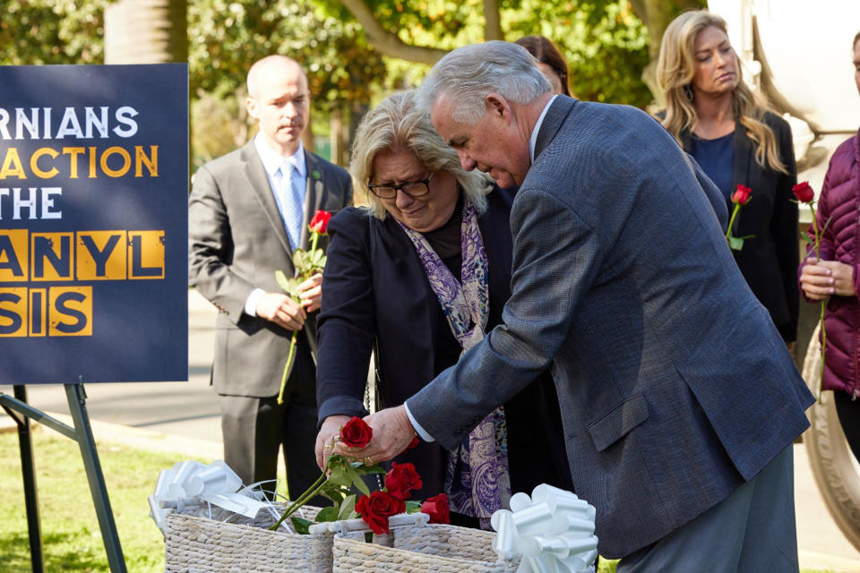 In this photo provided by Alex Bello, Fresno resident Pamela Smith and Assemblymember Jim Patterson lay down roses in a ceremony honoring fentanyl overdose victims at a news conference outside of the Capitol in Sacramento, Calif., Tuesday, April 18, 2023. Smith's only son died from a fentanyl overdose in 2016, and she has dedicated her life to fighting the fentanyl crisis. She supports stronger prison sentences for fentanyl dealers and was among dozens of protesters who called on the Assembly public safety to hear fentanyl-related bills. (Alex Bello/California Senate Republican Caucus via AP)