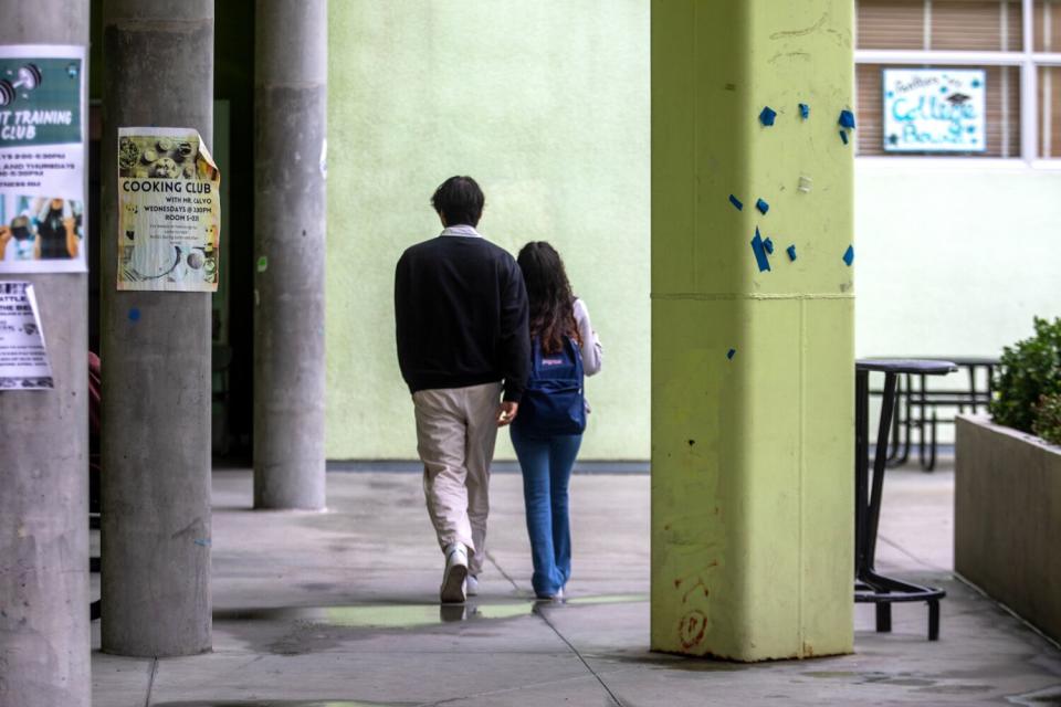 Jonathan Cornejo, left, and Emily Gramajo, right, walk to class through the courtyard at West Adams Preparatory High School