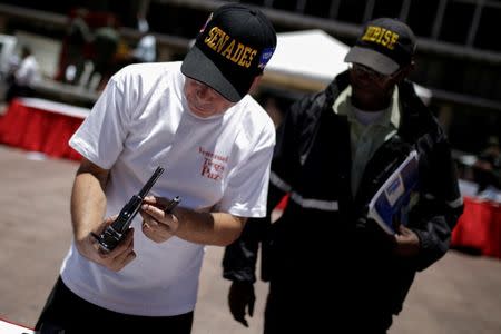 An official holds up a pistol during an exercise to disable seized weapons in Caracas, Venezuela August 17, 2016. REUTERS/Marco Bello