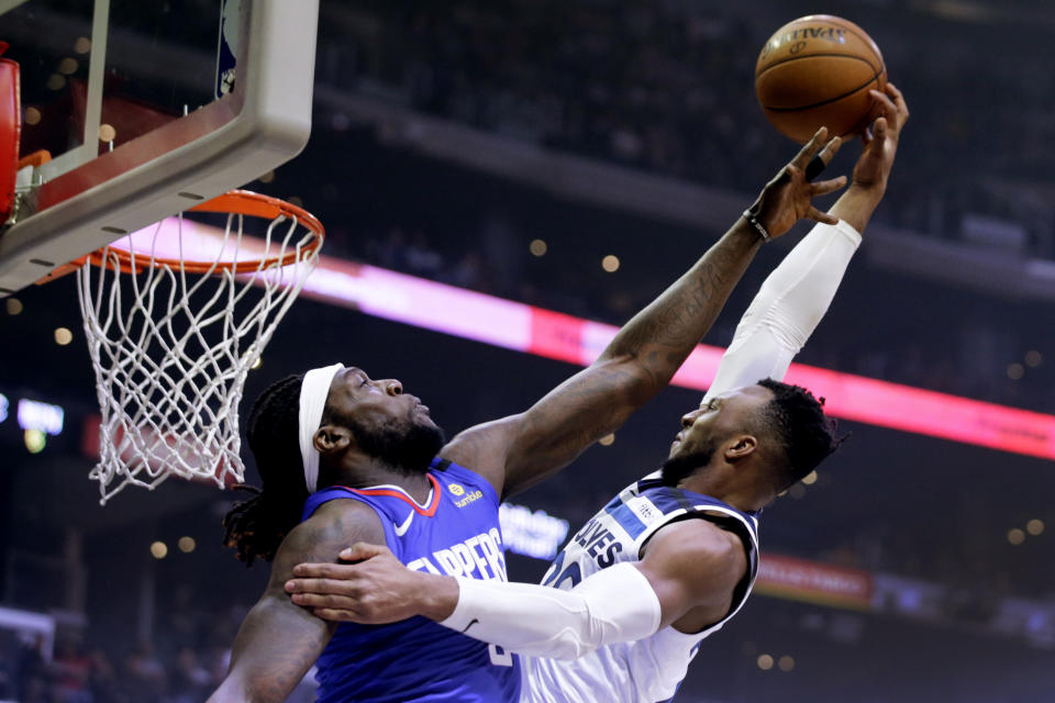 Minnesota Timberwolves guard Josh Okogie, right, shoots over Los Angeles Clippers forward Montrezl Harrell during the first half of an NBA basketball game in Los Angeles, Saturday, Feb. 1, 2020. (AP Photo/Alex Gallardo)