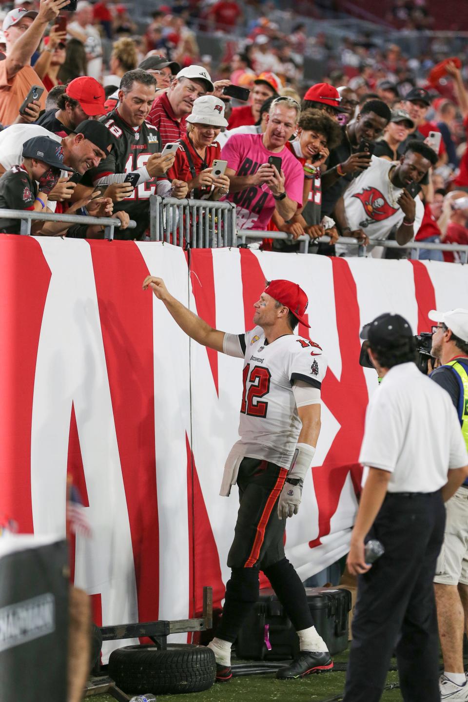 Tom Brady hands a hat to Noah Reeb and his father during Sunday's game in Tampa.