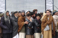 Afghans wait to receive food rations organized by the World Food Program (WFP) in Pul-e-Alam, the capital of Logar province. eastern of Afghanistan, Tuesday, Jan. 18, 2022. The Taliban's sweep to power in Afghanistan in August drove billions of dollars in international assistance out of the country and sent an already dirt-poor poor nation, ravaged by war, drought and floods, spiralling toward a humanitarian catastrophe. (AP Photo/Zubair Abassi)