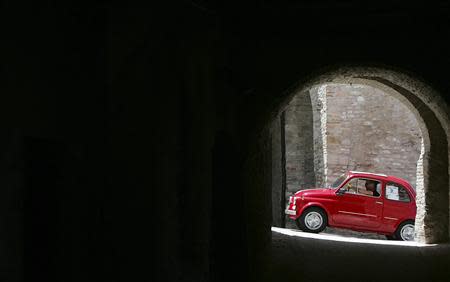 A member of the Italian Fiat 500 car club drives during a rally at the Fossato di Vico village in central Italy in this July 1, 2007 file photograph. REUTERS/Alessandro Bianchi/Files