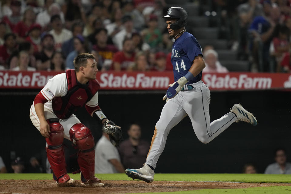Seattle Mariners' Julio Rodriguez (44) scores off of a single hit by Eugenio Suarez during the eighth inning of a baseball game against the Los Angeles Angels in Anaheim, Calif., Friday, Aug. 4, 2023. (AP Photo/Ashley Landis)