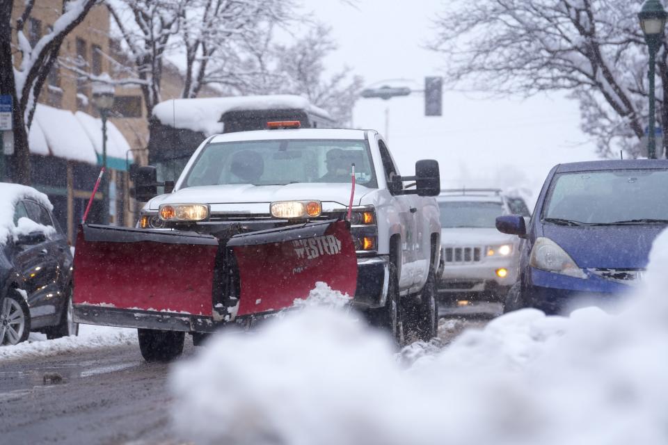 A snow plow drives through downtown Flagstaff during a heavy snow storm on Monday, Jan. 16, 2023.