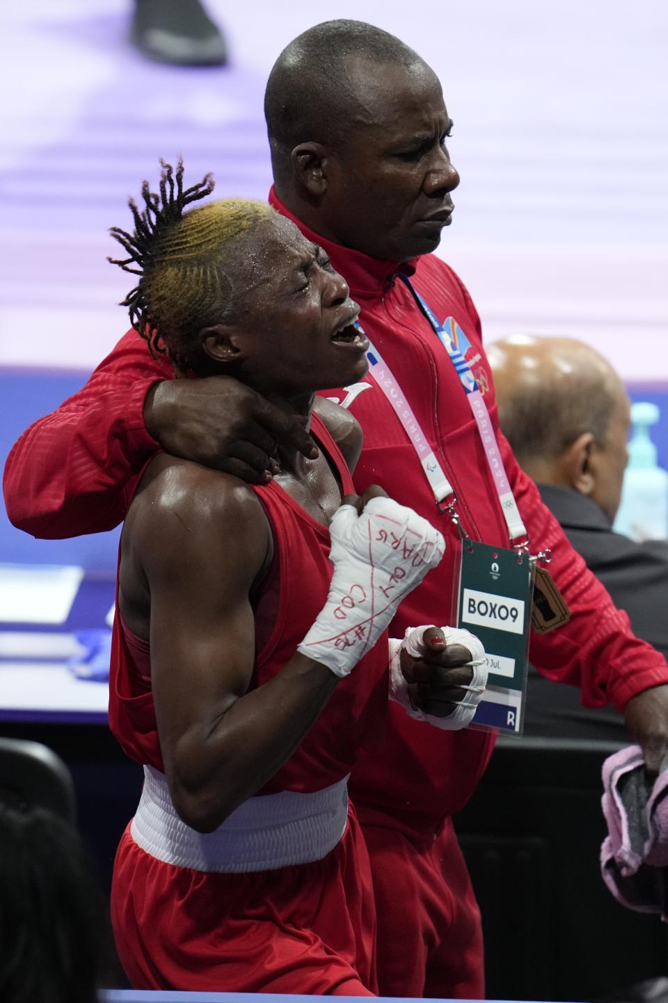 Democratic Republic of the Congo's Marcelat Sakobi, center, cries, after she was defeated by Uzbekistan's Sitora Turdibekova, in their women's 57kg boxing match at the 2024 Summer Olympics, Tuesday, July 30, 2024, in Paris, France. (AP Photo/Ariana Cubillos)