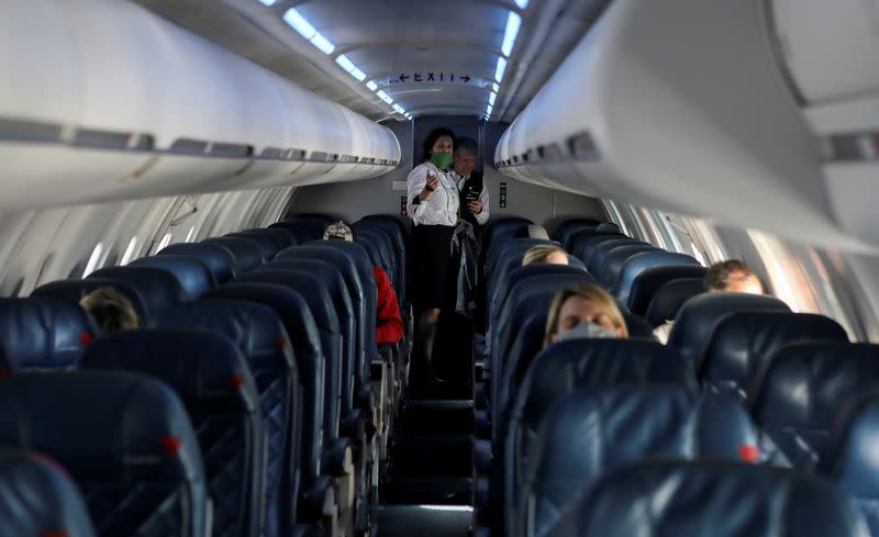 FILE PHOTO: Flight attendants talk in a nearly empty cabin on a Delta Airlines flight operated by SkyWest Airlines