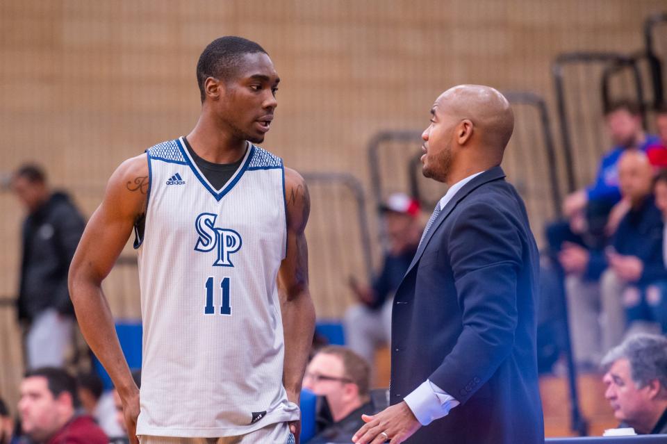 Saint Peter's forward KC Ndefo (left) speaks with Shaheen Holloway