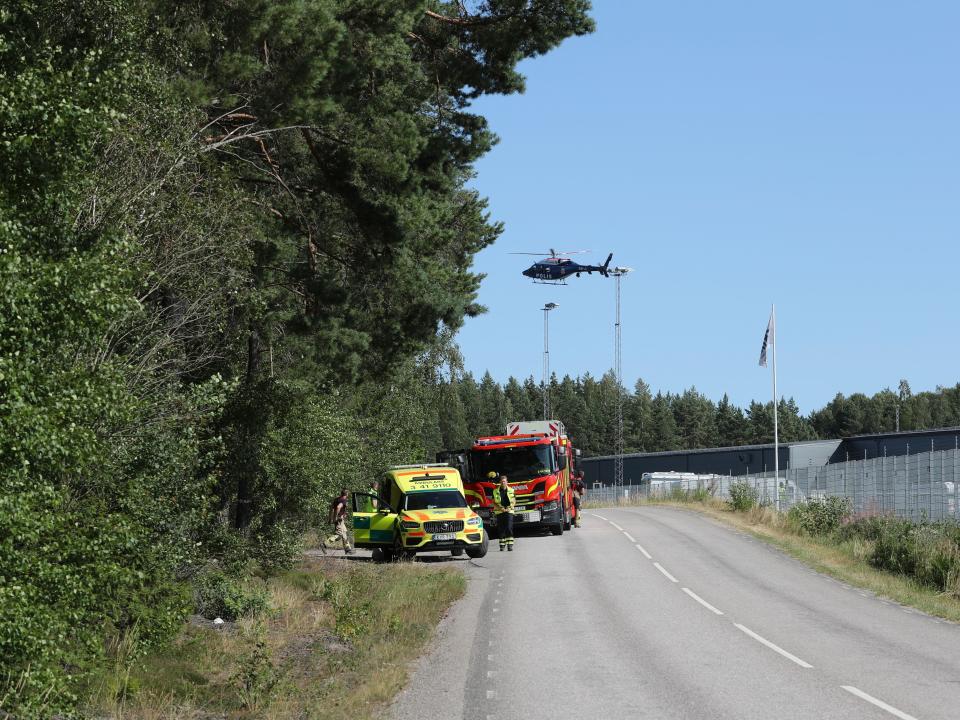 A medical car and personnel, a firetruck and a police helicopter are seen outside the Hallby Prison near Eskilstuna, Sweden, July 21, 2021.