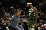 Milwaukee Bucks head coach Mike Budenholzer talks to DeMarcus Cousins during the first half of an NBA basketball game against the Cleveland Cavaliers Monday, Dec. 6, 2021, in Milwaukee. (AP Photo/Morry Gash)