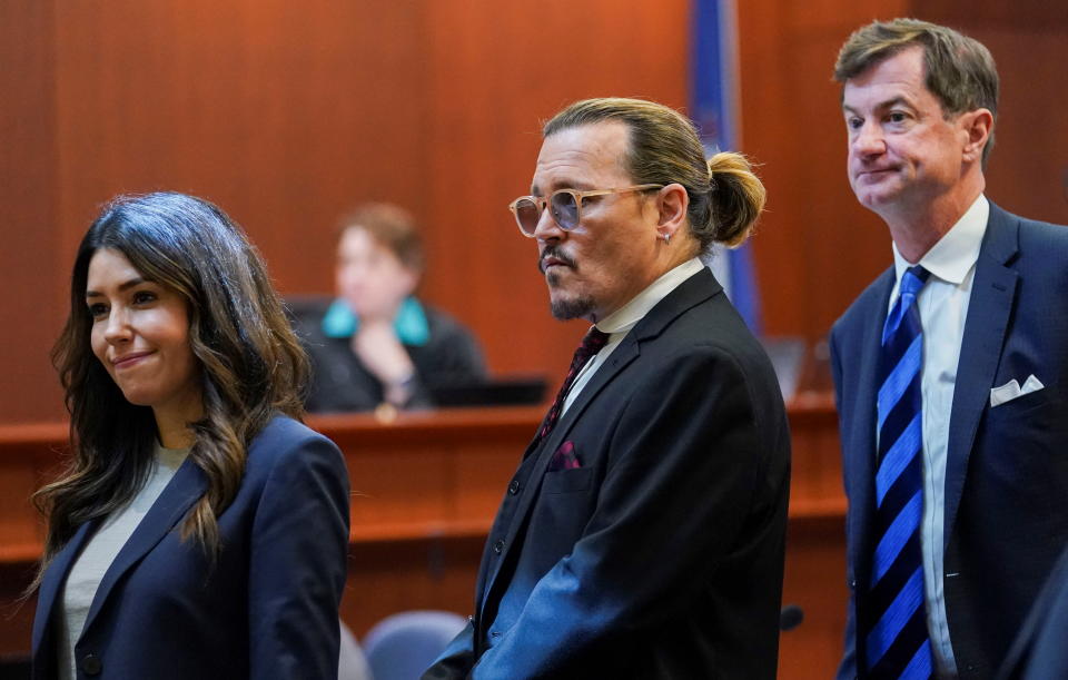 Johnny Depp stands next to his lawyers, Camille Vasquez and Ben Chew, after a break in the defamation trial against Amber Heard at the Fairfax County Circuit Courthouse in Fairfax, Virginia.