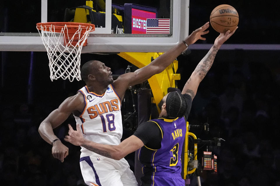 Los Angeles Lakers forward Anthony Davis, right, shoots as Phoenix Suns center Bismack Biyombo defends during the first half of an NBA basketball game Friday, April 7, 2023, in Los Angeles. (AP Photo/Mark J. Terrill)