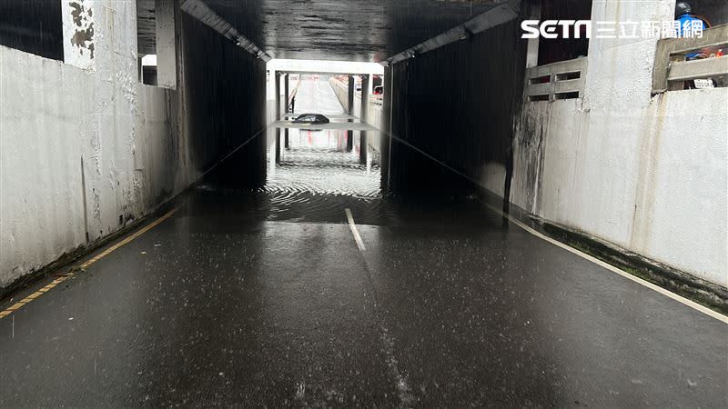 車主的愛車整輛車「卡住」水已經淹到車窗，駕駛緊急逃生，站在地下道另一處望著愛車，一臉無奈。。（圖／翻攝畫面）