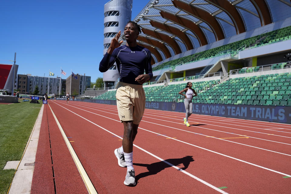 HOLD FOR STORY- Eric Gregory uses sign language to communicate with his coach as walks on the track at the U.S. Olympic Track and Field Trials, Wednesday, June 19, 2024, in Eugene, Oregon. The deaf sprinter from Gallaudet University in Washington, D.C., earned the last spot into the 400-meter field at the U.S. Olympic Trials this week. (AP Photo/Charlie Neibergall)