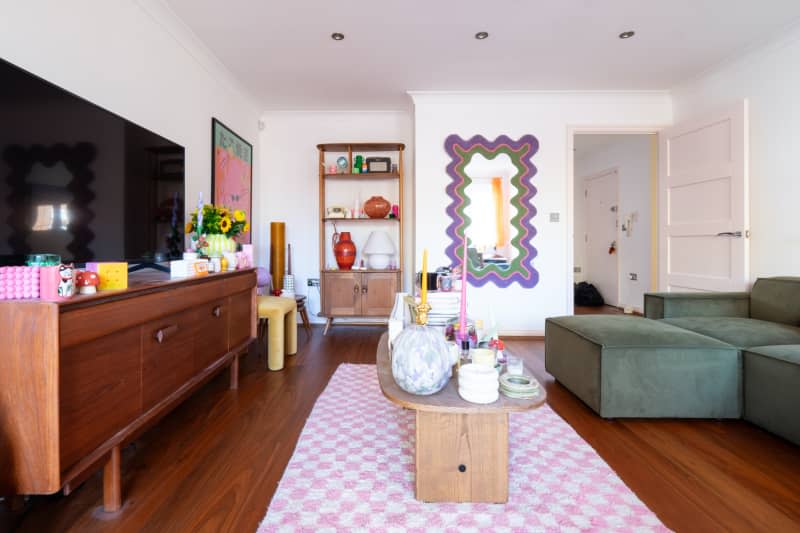 View of white living room with colorful accessories.