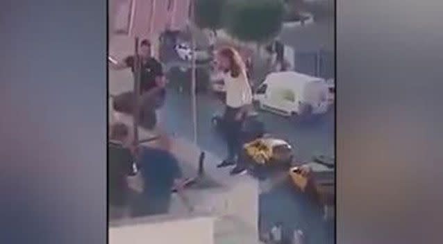 The cop crouches on the balcony ledge beside the girl. Picture: LiveLeak