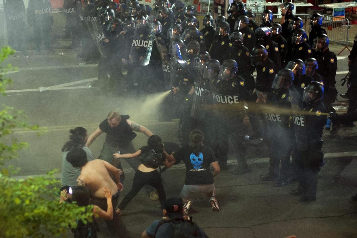 Reeling: Protesters recoil after being pepper-sprayed by police in Phoenix