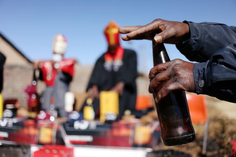 A congregant of Gabula Church holds a bottle as he prays over it during a service in Evaton