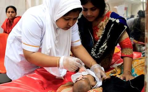 Baby Sammiya is watched over by her mother as as she is treated by a nurse at the International Centre for Diarrhoeal Disease Research, Bangladesh - Credit: Susannah Savage