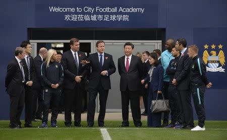 Britain's Prime Minister David Cameron (C) stands with China's President Xi Jinping (centre R) and Manchester City Chairman Khaldoon Al Mubarak (2nd R) during a visit to the City Football Academy in Manchester, Britain October 23, 2015. REUTERS/Joe Giddens/pool