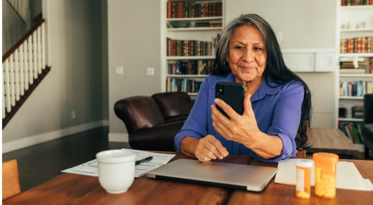 A woman calculates how much her Social Security benefits will be using her phone.