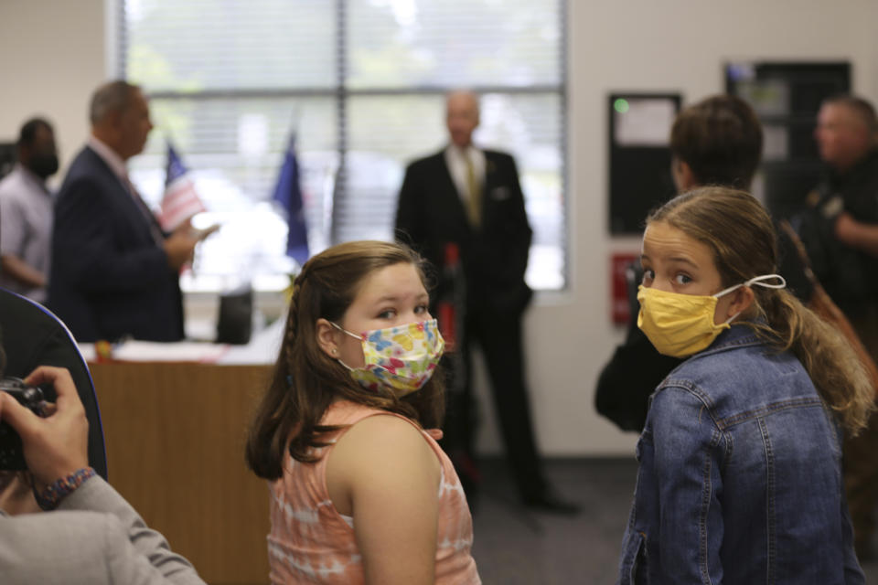 Two Camden Elementary School students in masks listen as South Carolina Gov. Henry McMaster talks about steps the school is taking to fight COVID-19, Wednesday, Sept. 15, 2021, in Camden, S.C. McMaster has adamantly and repeatedly come out against requiring masks in schools even as the average number of daily COVID-19 cases in the state has risen since early June. (AP Photo/Jeffrey Collins)