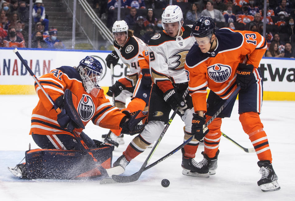 Anaheim Ducks' Troy Terry (19) is stopped by Edmonton Oilers goalie Mike Smith (41) as Jesse Puljujarvi (13) defends during the first period of an NHL hockey game Tuesday, Oct. 19, 2021, in Edmonton, Alberta. (Jason Franson/The Canadian Press via AP)