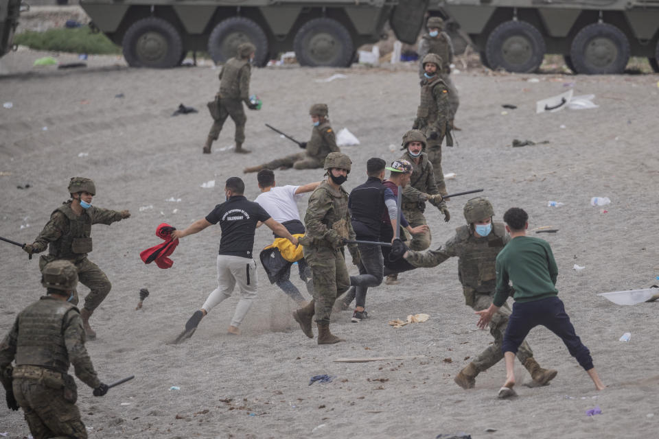 Spanish Army soldiers clash with migrants near the border of Morocco and Spain, at the Spanish enclave of Ceuta, on Tuesday, May 18, 2021. (AP Photo/Bernat Armangue)