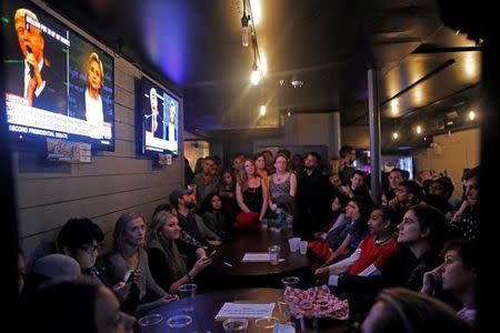 People gather to watch the presidential town hall debate at Village Pourhouse Downtown bar in Manhattan, New York, U.S., October 9, 2016. REUTERS/Andrew Kelly