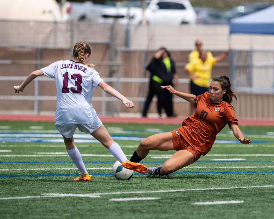 Mia Wiele of Westwood (10) slides in to defend against Round Rock's Zoe Dick last season. Westwood won a girls regional final soccer playoff match 3-0 over Round Rock at Comalander Stadium on April 8, 2023.