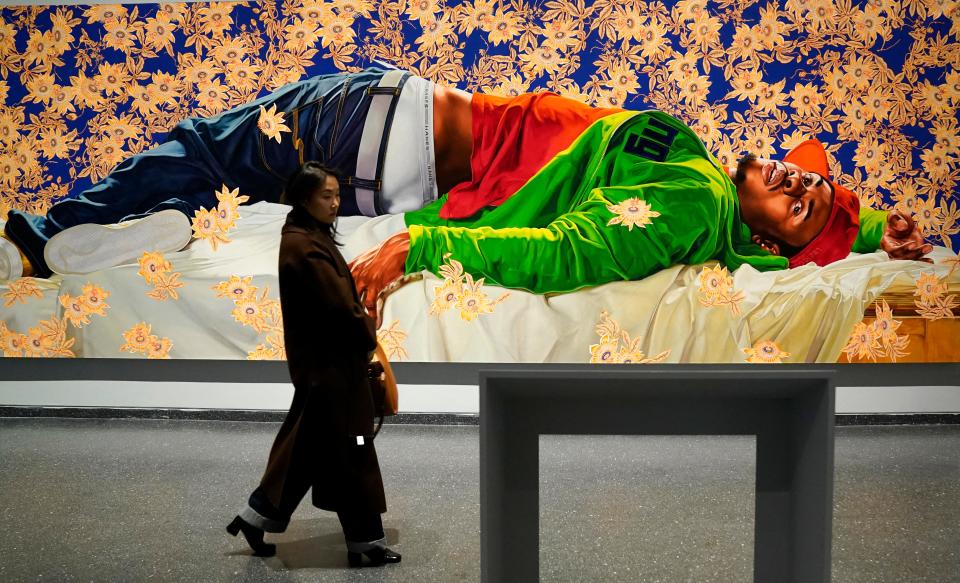 A person walks past Kehinde Wiley's "Femme piquÃe par un serpent" during a press preview of the exhibition Giants Art from the Dean Collection of Swizz Beatz and Alicia Keys at the Brooklyn Museum in New York on February 6, 2024.