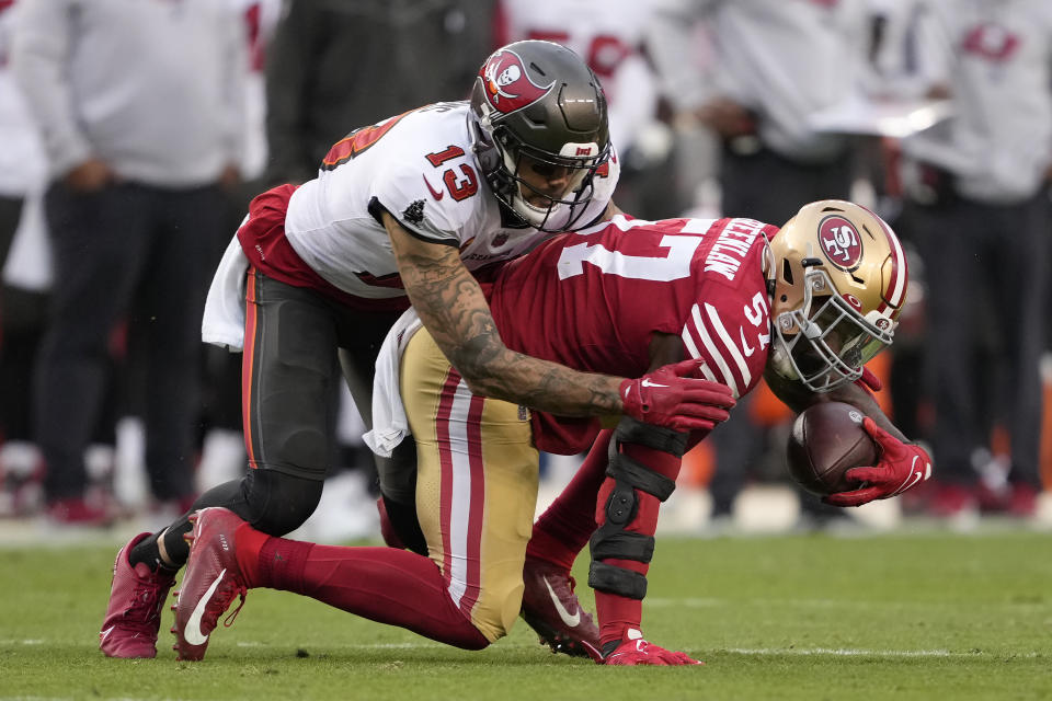 San Francisco 49ers linebacker Dre Greenlaw, right, intercepts a pass in front of Tampa Bay Buccaneers wide receiver Mike Evans during the second half of an NFL football game in Santa Clara, Calif., Sunday, Dec. 11, 2022. (AP Photo/Tony Avelar)