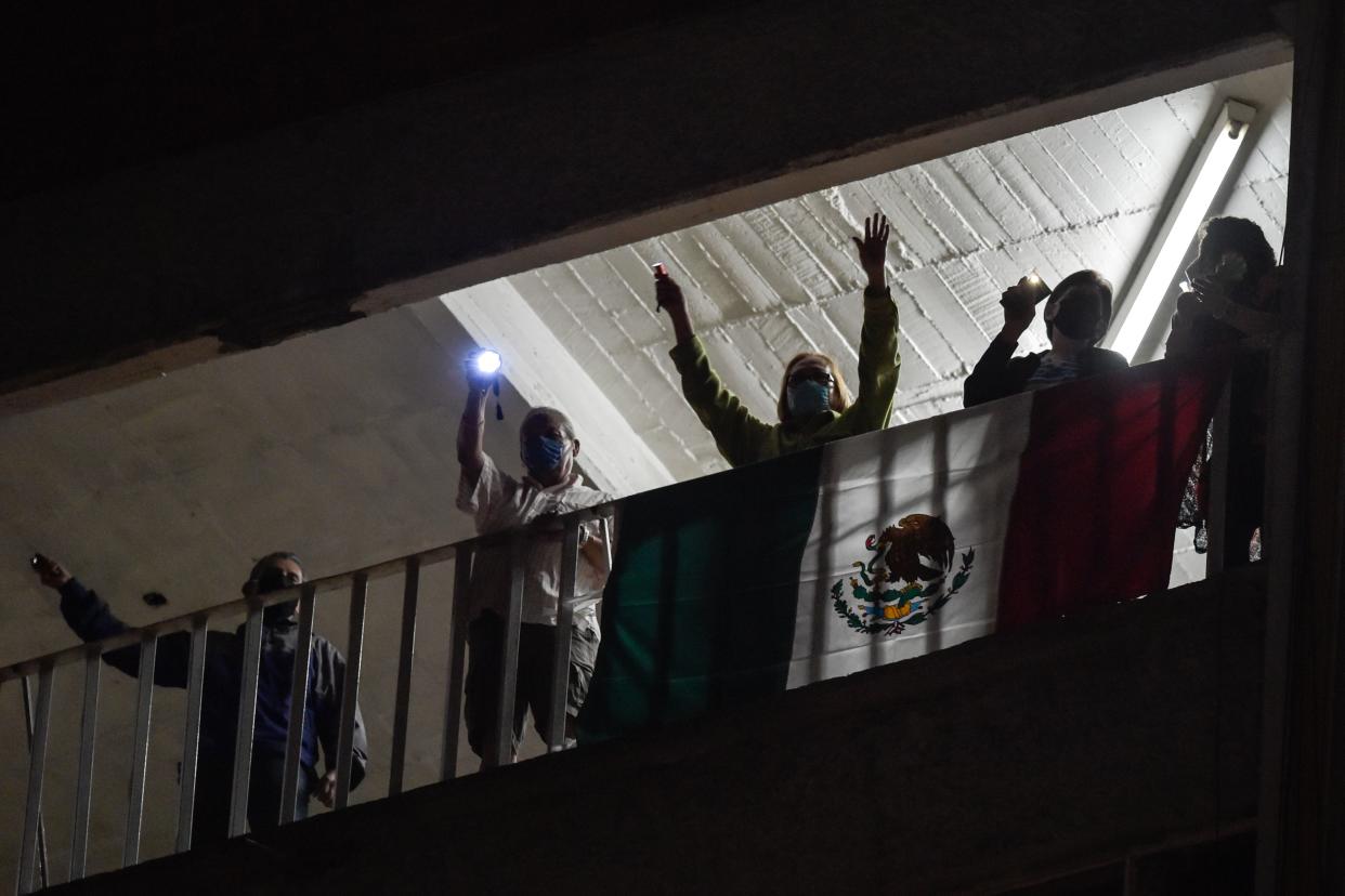 Los residentes de un edificio cerca del Hospital "20 de Noviembre" cantan para alabar al personal médico y a los pacientes en la Ciudad de México. Foto de Pedro Pardo / AFP vía Getty Images.