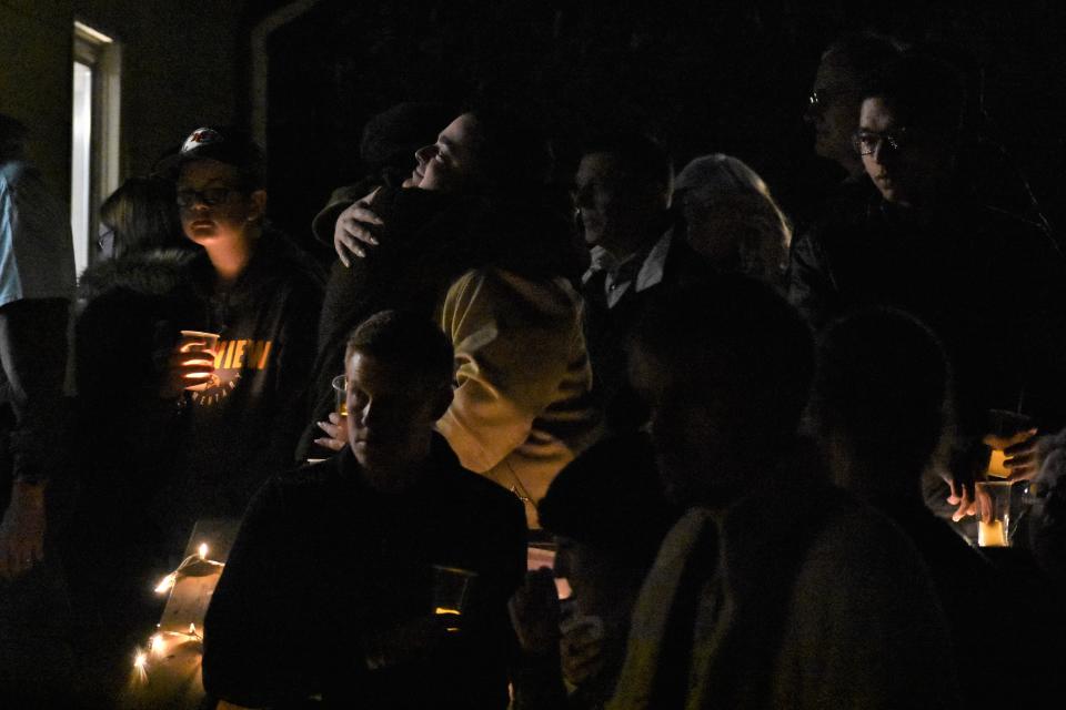 Attendees embrace and gather during a candlelight vigil on Nov. 22, 2022, at the Center Project house in Columbia, Mo.
