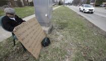 Edmond Aviv sits on a street corner holding a sign Sunday, April 13, 2014, in South Euclid, Ohio declaring he's a bully, a requirement of his sentence because he was accused of harassing a neighbor and her disabled children for the past 15 years. Municipal Court Judge Gayle Williams-Byers ordered Aviv, 62, to display the sign for five hours Sunday. It says: "I AM A BULLY! I pick on children that are disabled, and I am intolerant of those that are different from myself. My actions do not reflect an appreciation for the diverse South Euclid community that I live in." (AP Photo/Tony Dejak)